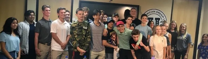 A large group of teens and young adults posing together for a photo at a workshop.