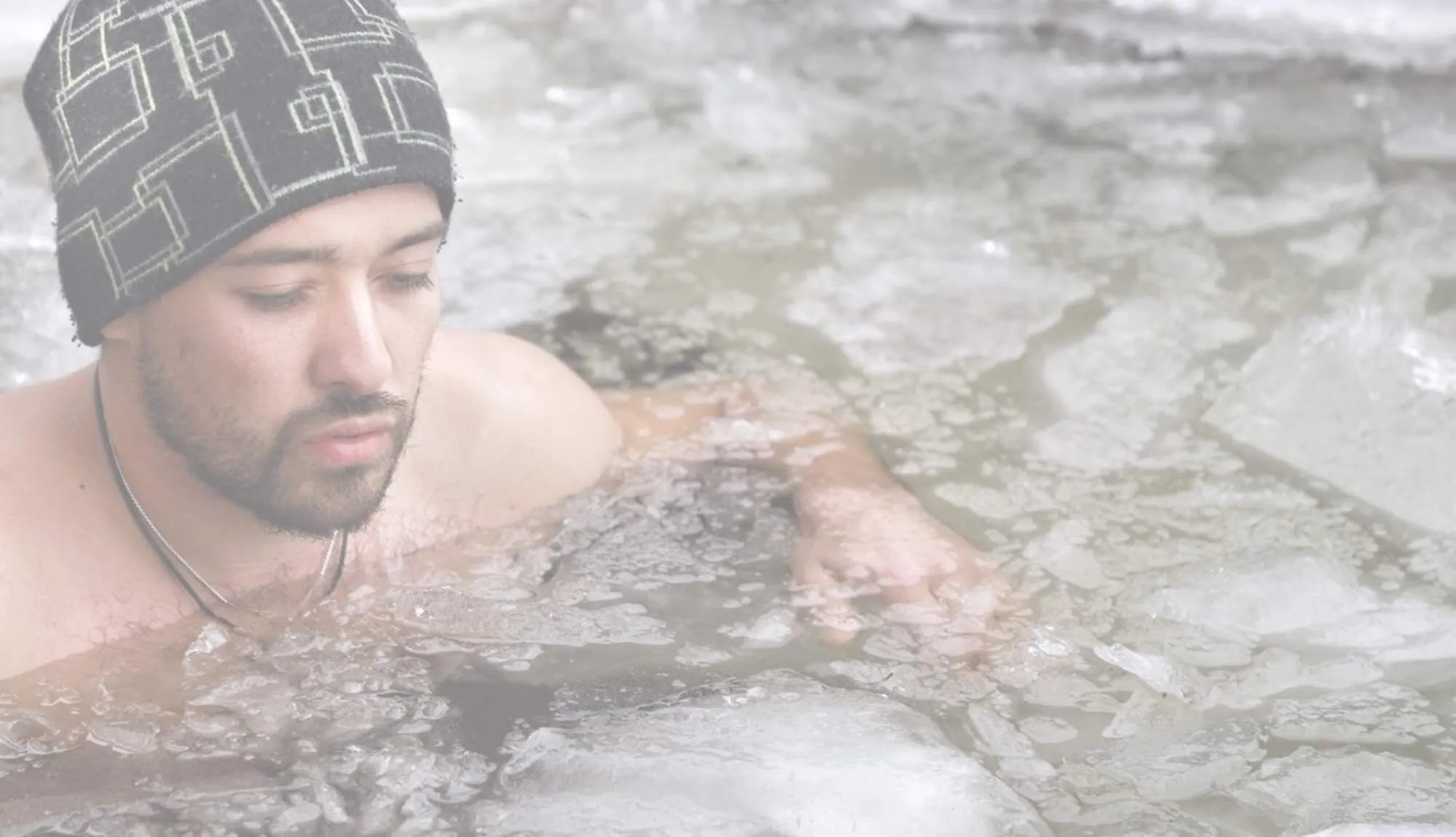 Wim Hof instructor Pavel Stuchlik in a beanie, immersed in icy water.